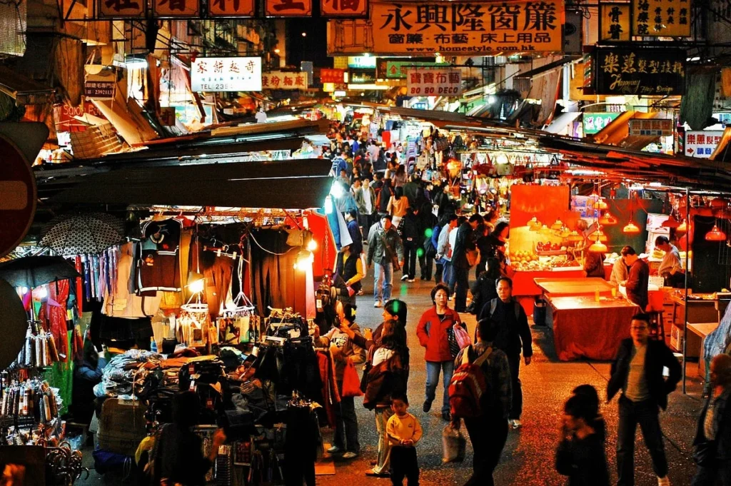 Crowded urban night market in China with young shoppers exploring street retail stalls and digital payment culture