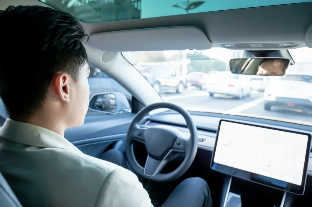Driver seated in a modern car with dashboard screen visible