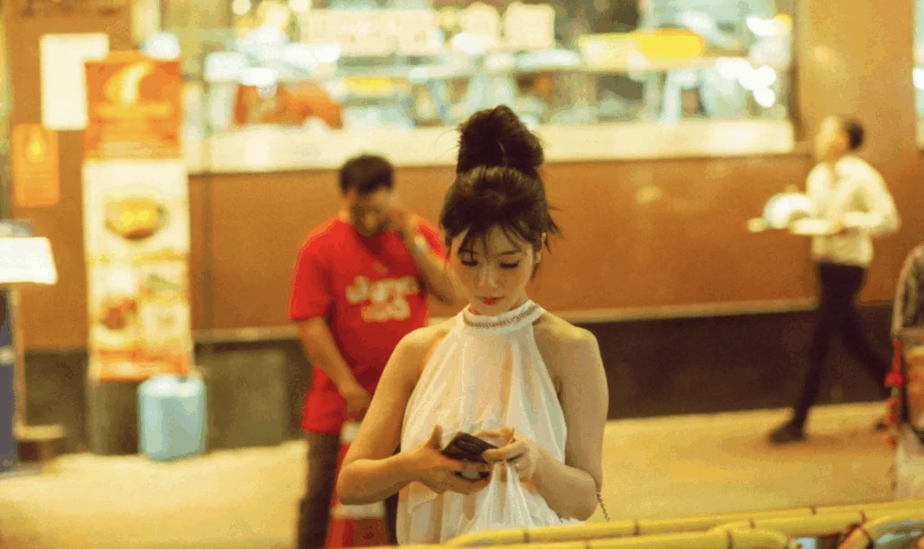 Young woman using a smartphone in a shopping mall illustrating mobile-first consumer behavior in China