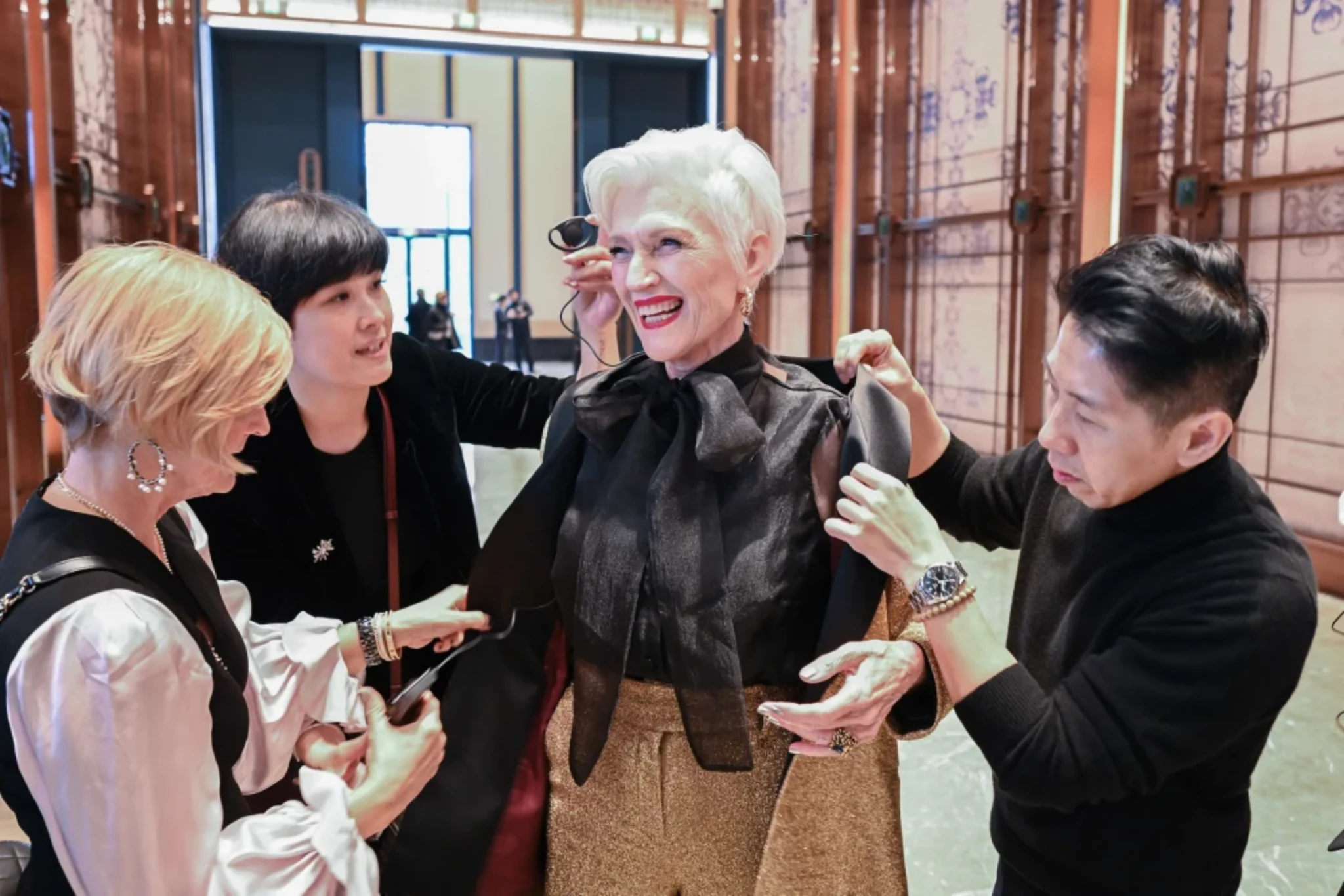 Fashion team adjusting outfit during luxury brand event