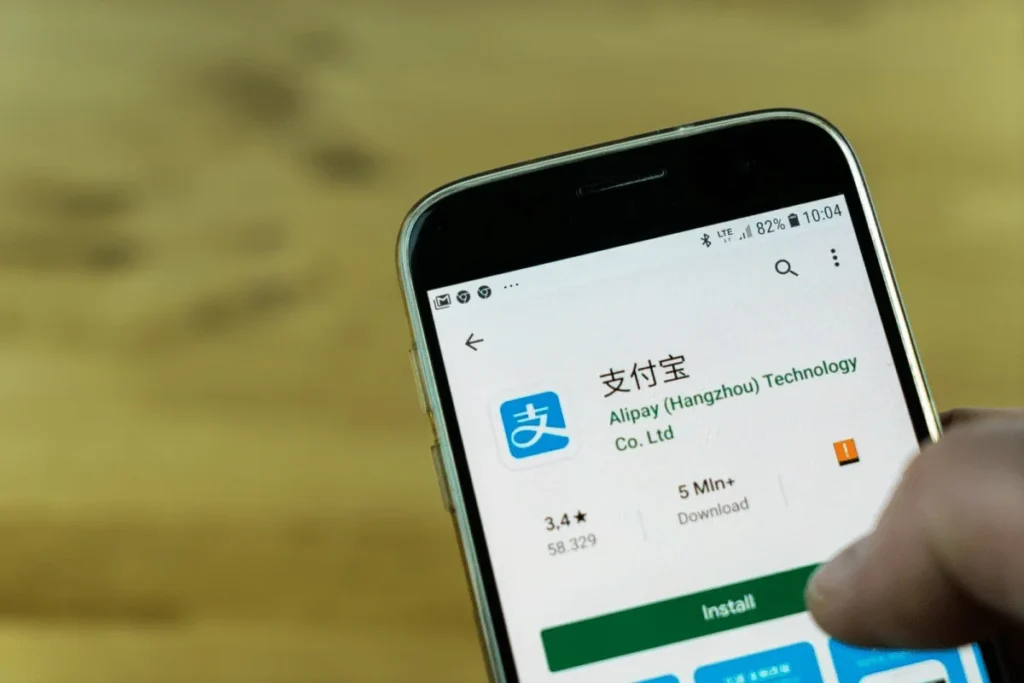 Smartphone screen showing Alipay app install page on Google Play with install button visible