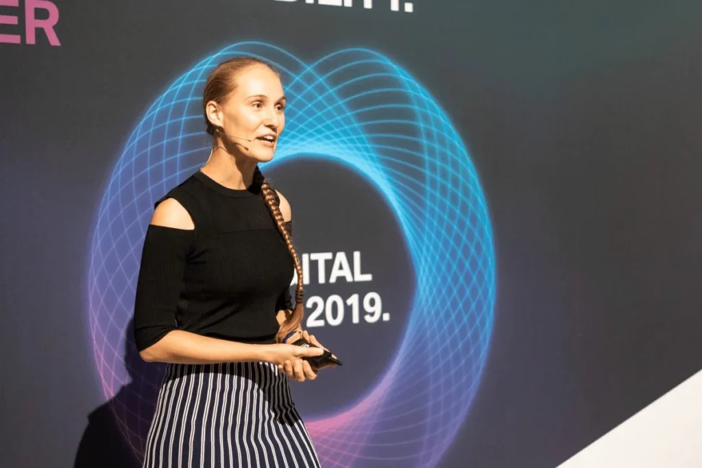 Woman giving a presentation on stage at a digital conference