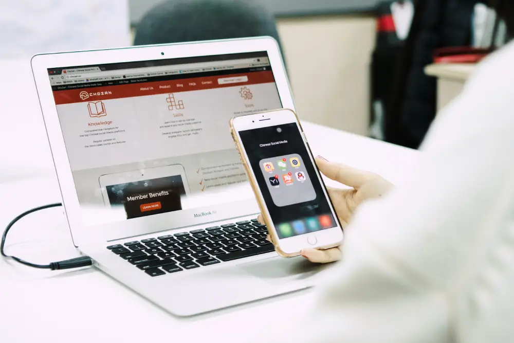 Smartphone and laptop displaying digital platforms side by side