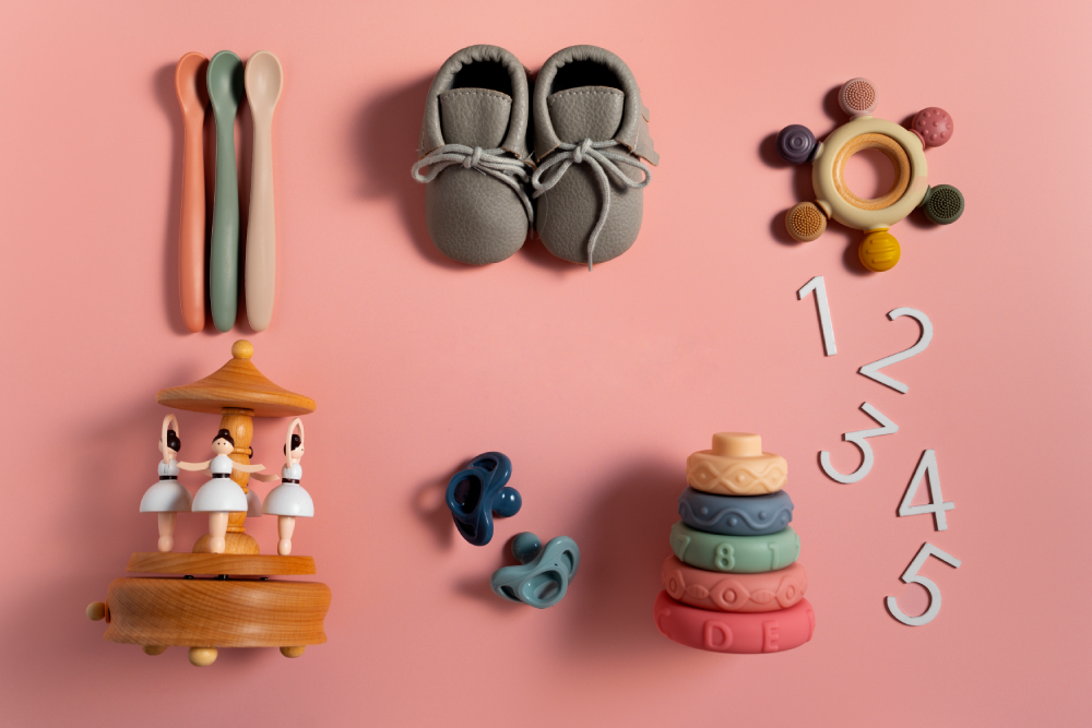 Flat lay of baby toys, shoes, spoons, and numbers