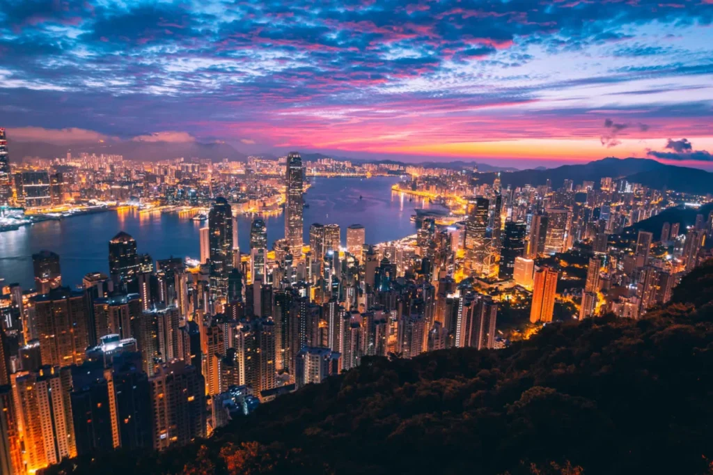 Panoramic evening view of Hong Kong’s skyline and Victoria Harbour during statutory holidays, reflecting leisure travel and nighttime consumer activity.